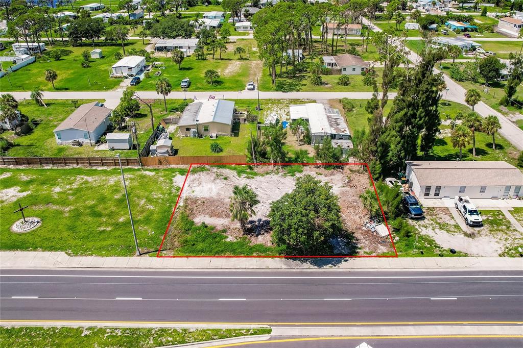 An aerial view shows a vacant, rectangular lot outlined in red next to a house — 3220 PLACIDA ROAD, ENGLEWOOD, FL