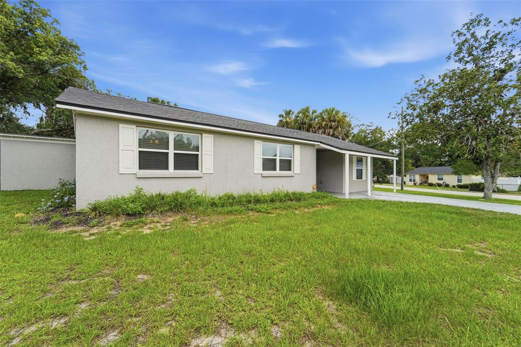 A single-story house with a gray stucco exterior, white shutters, and a covered front porch — 259 COLOMBA ROAD, DEBARY, FL