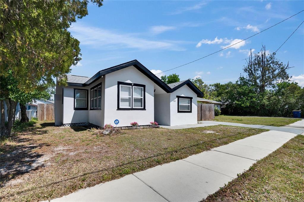 A white, single-story house with black trim and a sidewalk in the front yard — 1138 HOWARD STREET, CLEARWATER, FL