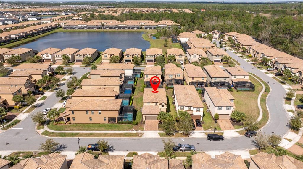 An aerial view shows a suburban neighborhood with tan houses, a lake, and a red pin — 8877 BENGAL COURT, KISSIMMEE, FL
