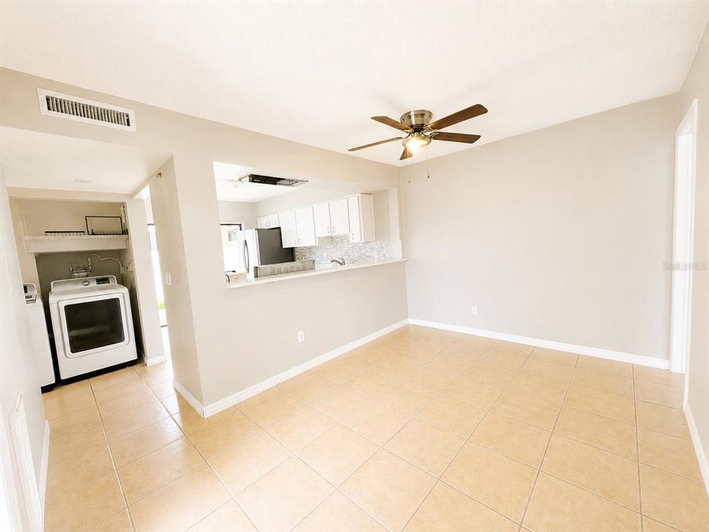 A dining area with tile floors, a ceiling fan, and an open view into the kitchen — 5104 SPRINGWATER COURT, TAMPA, FL