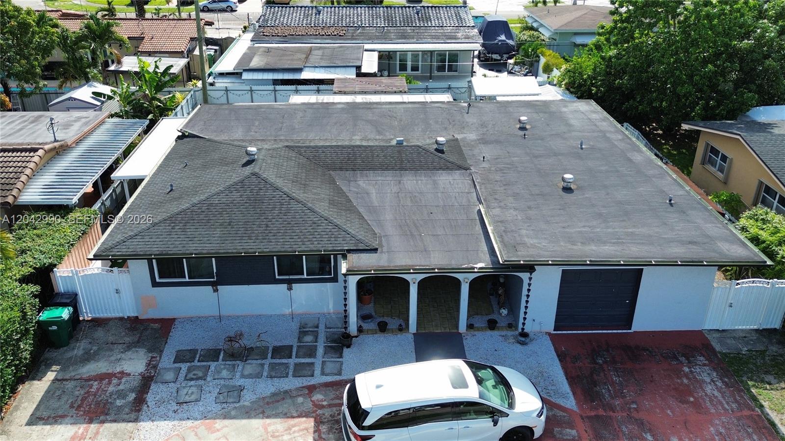 An aerial view shows a house with a combination of shingled and flat roofing — 11512 NW 58th Ave, Hialeah FL 33012, HIALEAH, FL
