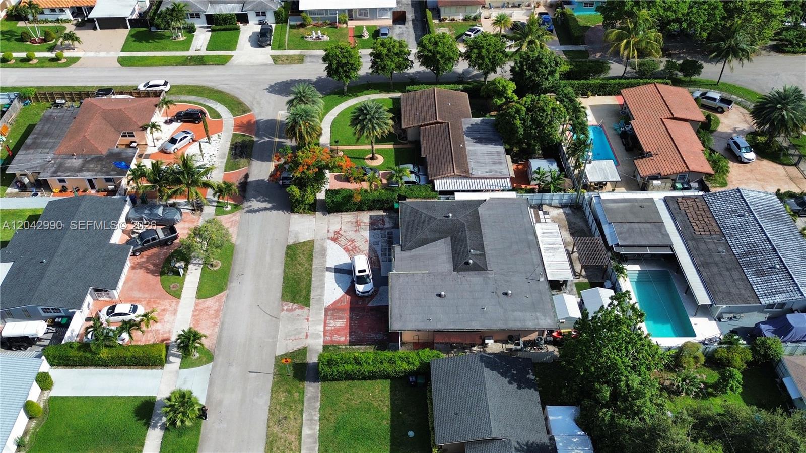 An aerial view shows several suburban houses with swimming pools and driveways in a neighborhood — 11512 NW 58th Ave, Hialeah FL 33012, HIALEAH, FL