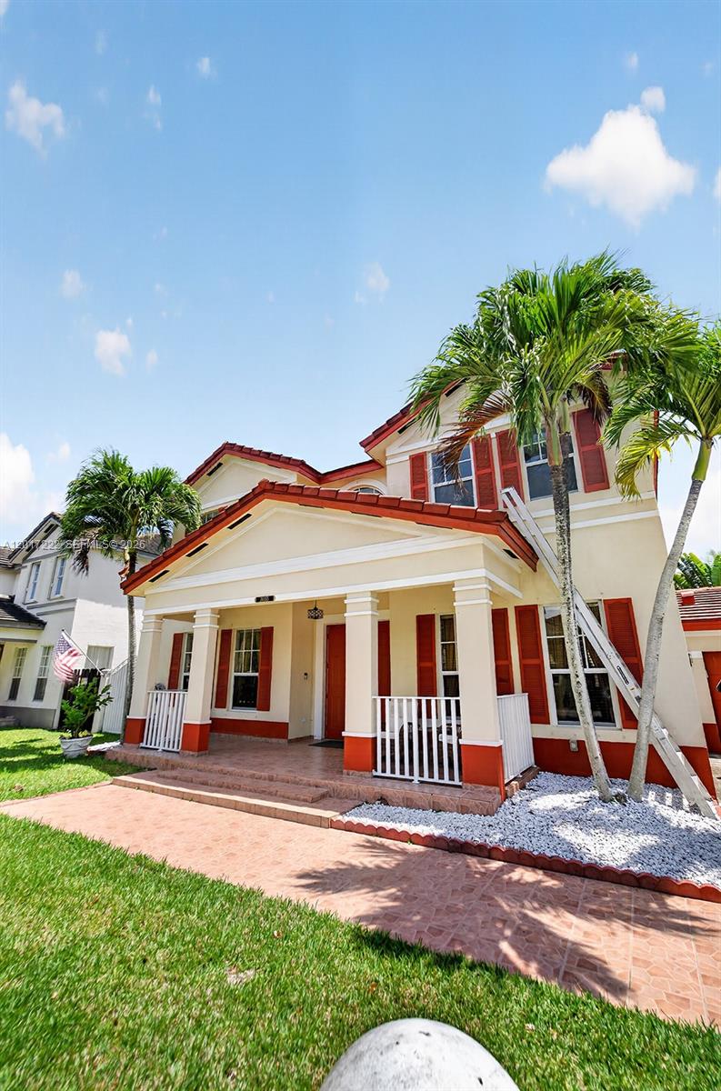 A two-story house with a covered front porch, red tile roof, and palm trees — 20155 SW 129th Ave, Miami FL 33177, MIAMI, FL