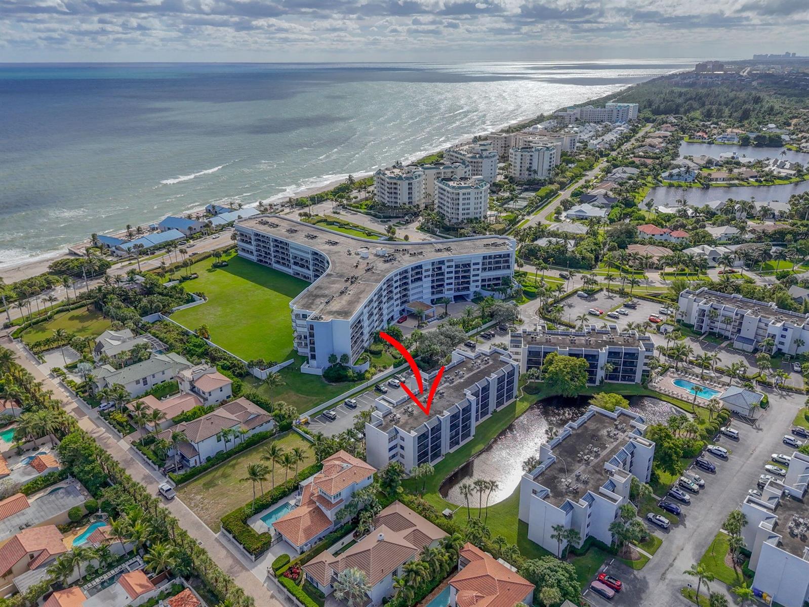 An aerial view shows a multi-story residential building with a red arrow pointing toward it — 1605 S Us Highway 1 # A407, Jupiter FL 33477, JUPITER, FL
