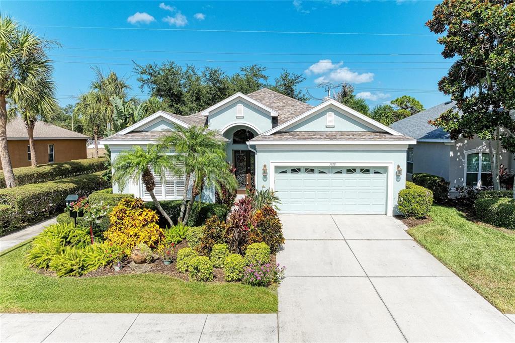 A light blue single-story house with a two-car garage and landscaped front yard — 3728 SUMMERWIND CIRCLE, BRADENTON, FL