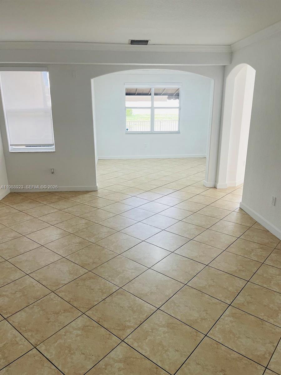 An interior room features light-colored tile flooring and an arched entryway leading to another space — 8666 NW 109th Ct # 8666, Doral FL 33178, DORAL, FL