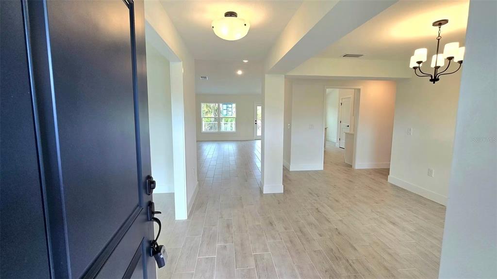 An entryway leads into an open-concept living area with light wood-look tile flooring — 2239 N BISCAYNE DRIVE, NORTH PORT, FL