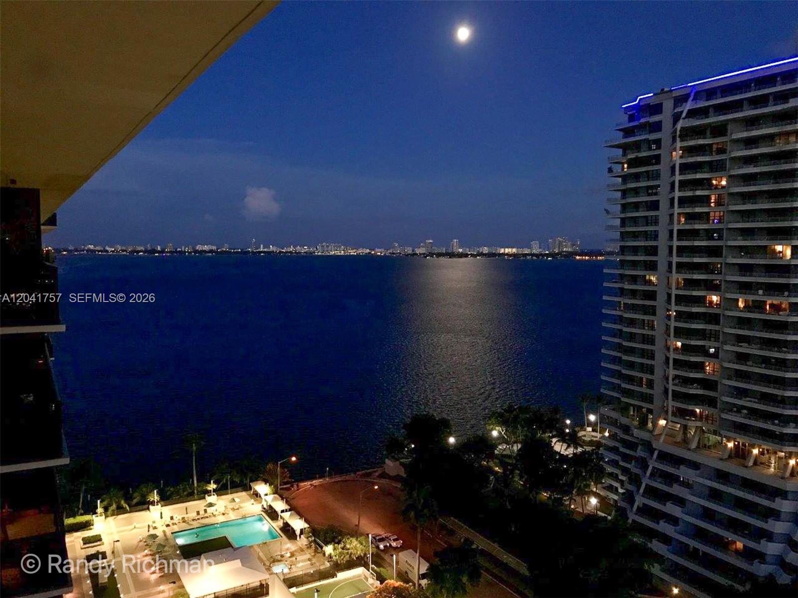 A high-angle view shows a waterfront pool area and a tall building at night — 600 NE 36th St, Miami FL 33137, MIAMI, FL