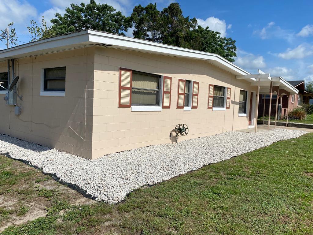 A tan concrete block house with brown shutters and a white rock landscape bed — 3408 LEEMOORE PLACE, ORLANDO, FL
