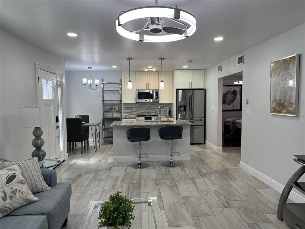 A kitchen island with a granite countertop and stainless dishwasher faces a living room area — 1742 8TH STREET, SARASOTA, FL