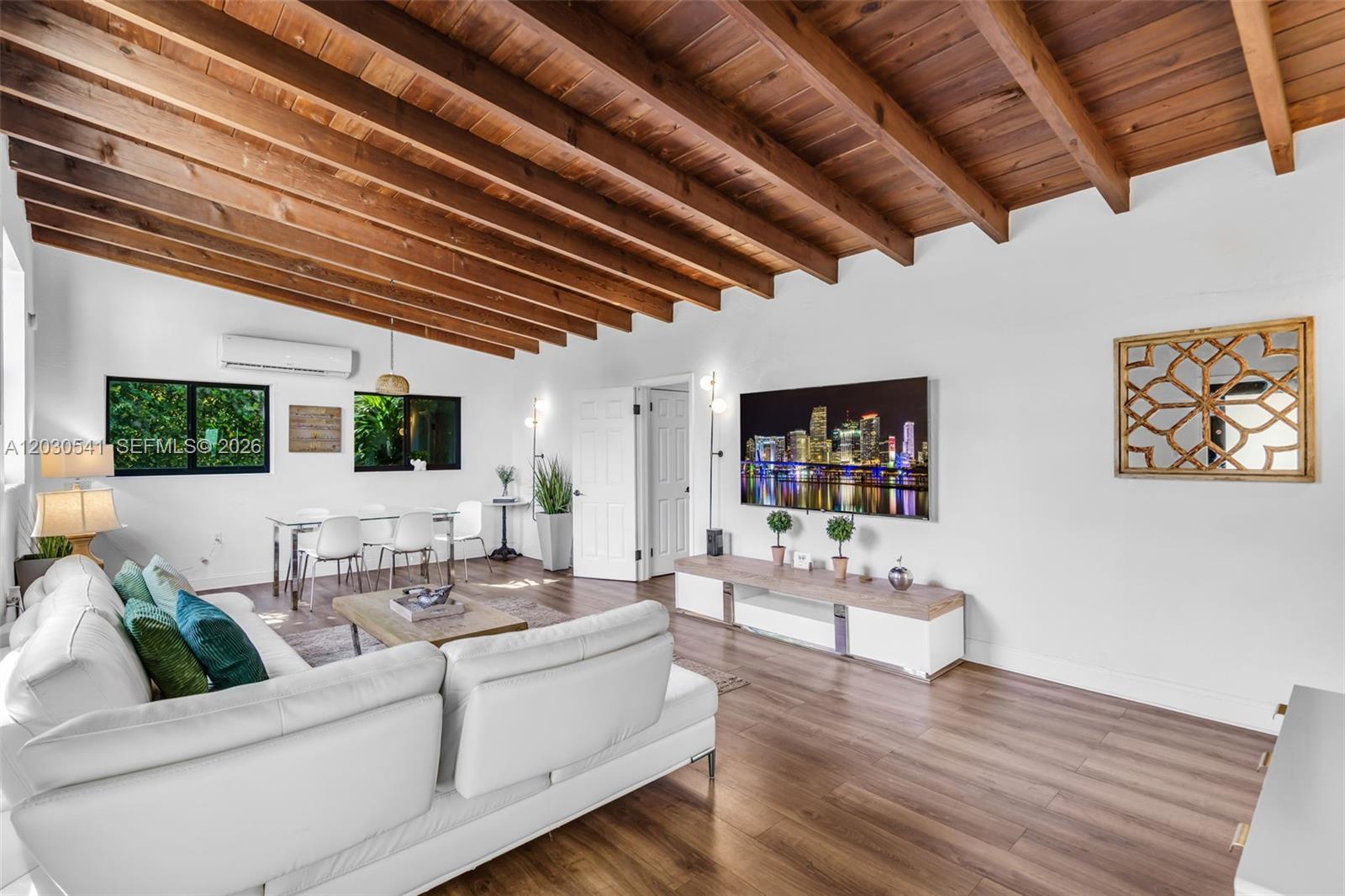 A living room features a vaulted wood-beam ceiling, white walls, and a white sectional sofa — 11534 NE 13th Ave, Miami FL 33161, MIAMI, FL