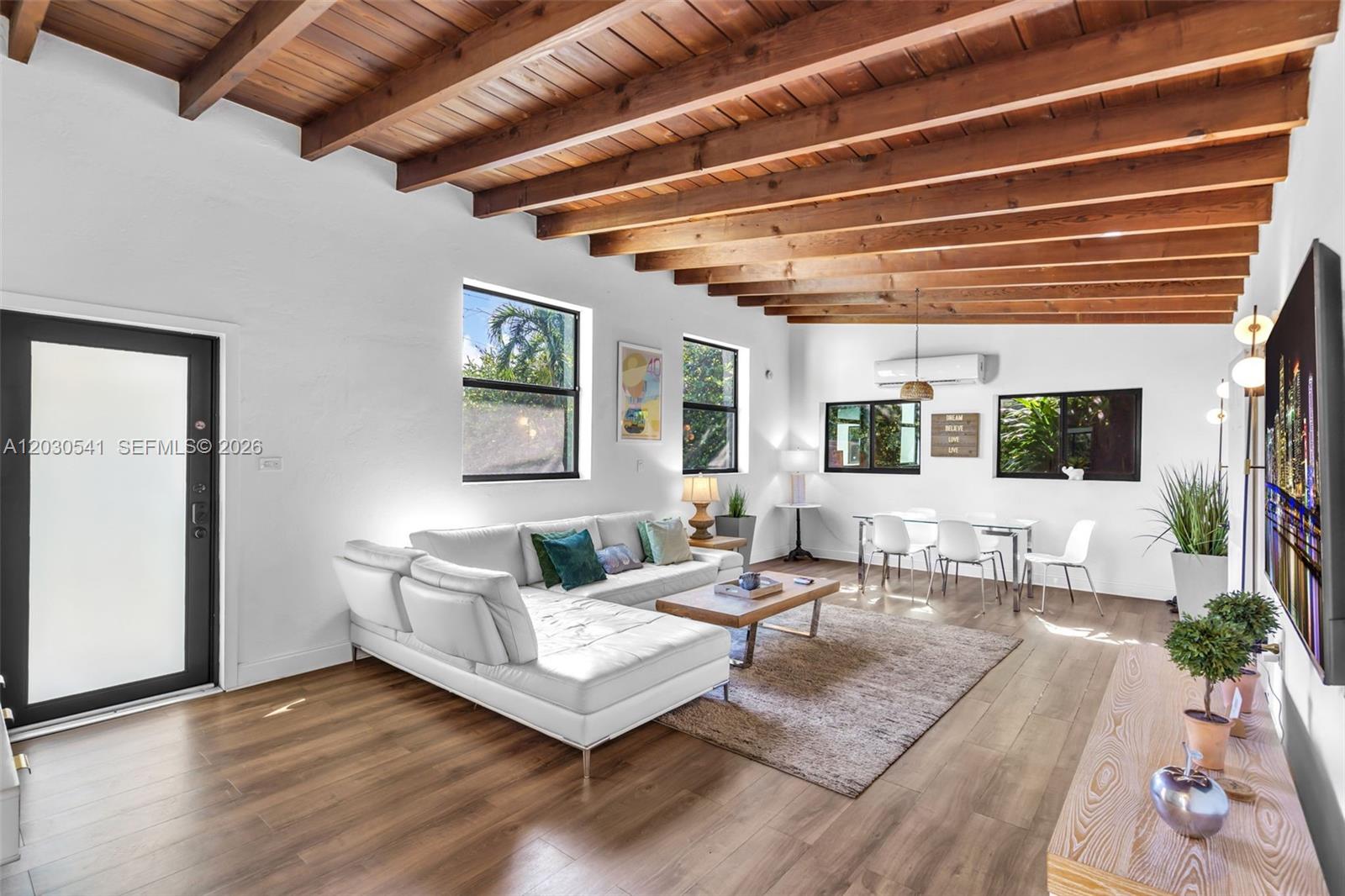A living room features a white sectional sofa, wood-beamed ceiling, and light wood flooring — 11534 NE 13th Ave, Miami FL 33161, MIAMI, FL
