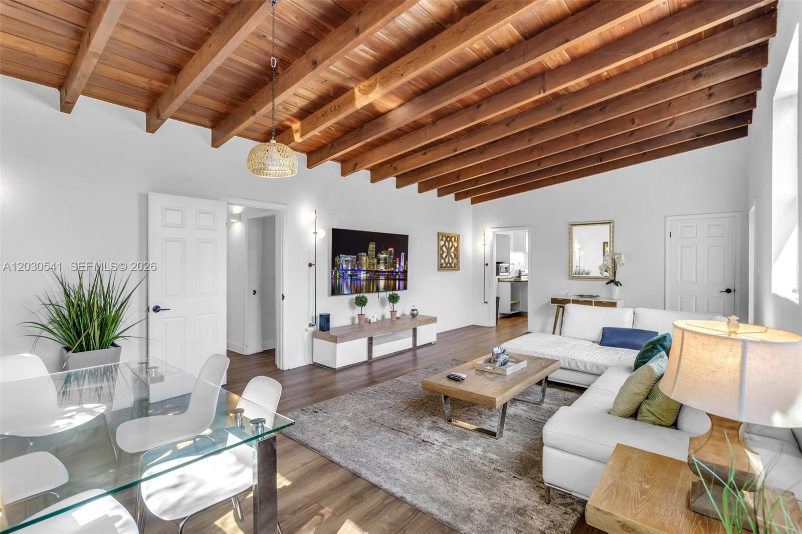 A living room features a vaulted wood-beamed ceiling, white walls, and a glass dining table — 11534 NE 13th Ave, Miami FL 33161, MIAMI, FL
