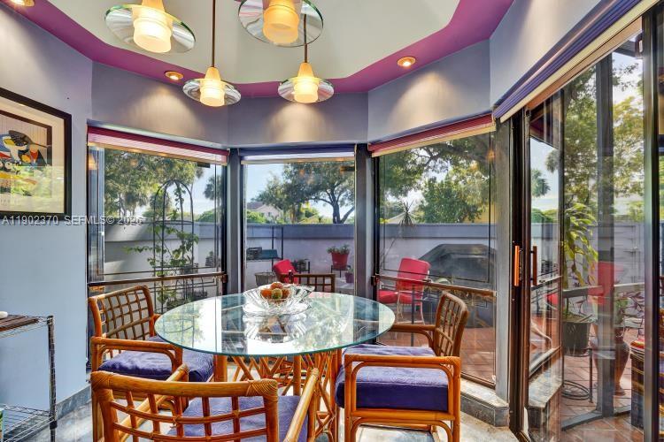 A patio with red chairs, a small table, potted plants, and a covered grill — 10026 NW 52nd Ter, Doral FL 33178, DORAL, FL