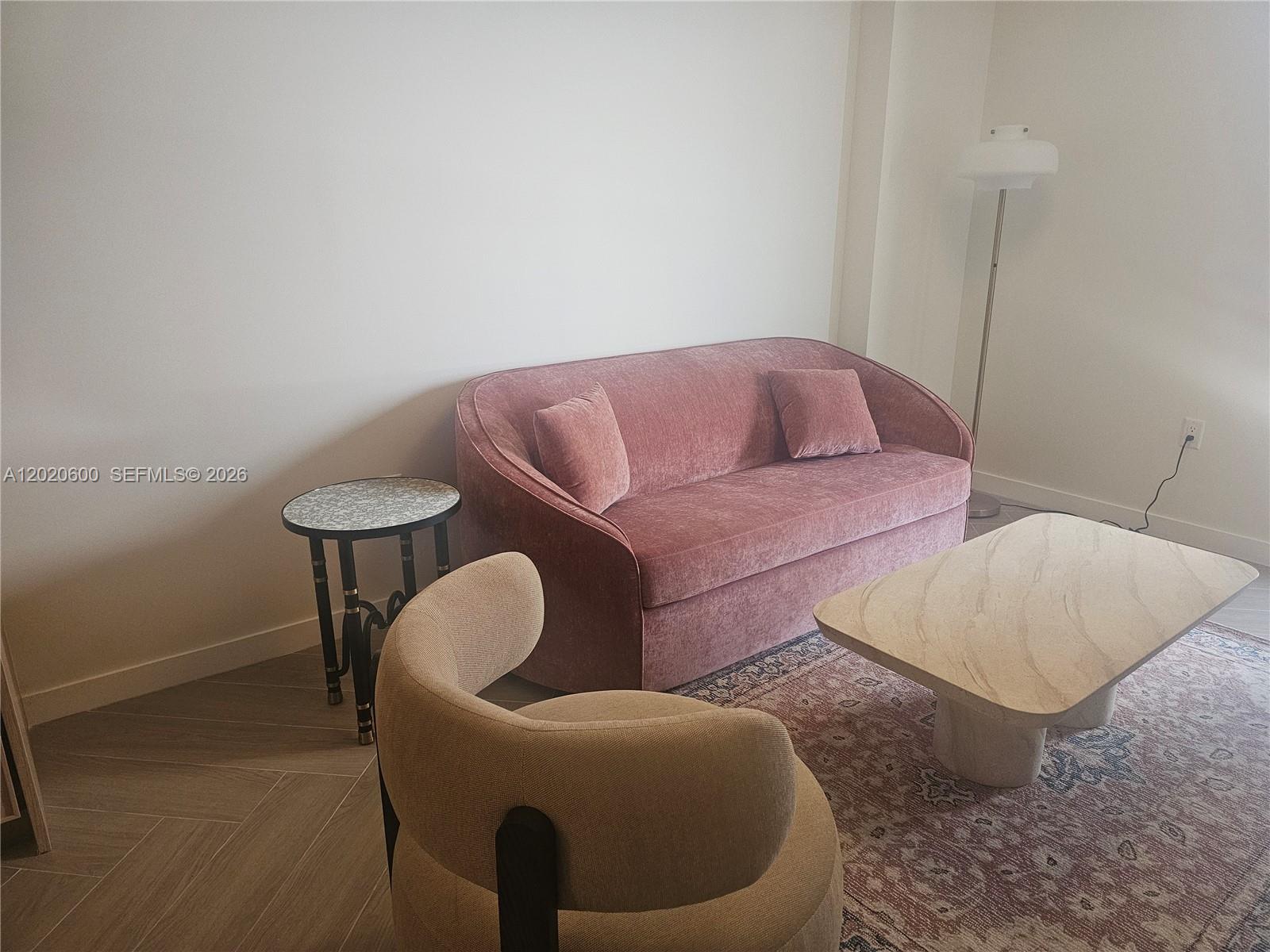 A living room features a pink velvet sofa, a beige curved chair, and a coffee table — 2700 NW 2nd Ave # 312, Miami FL 33127, MIAMI, FL