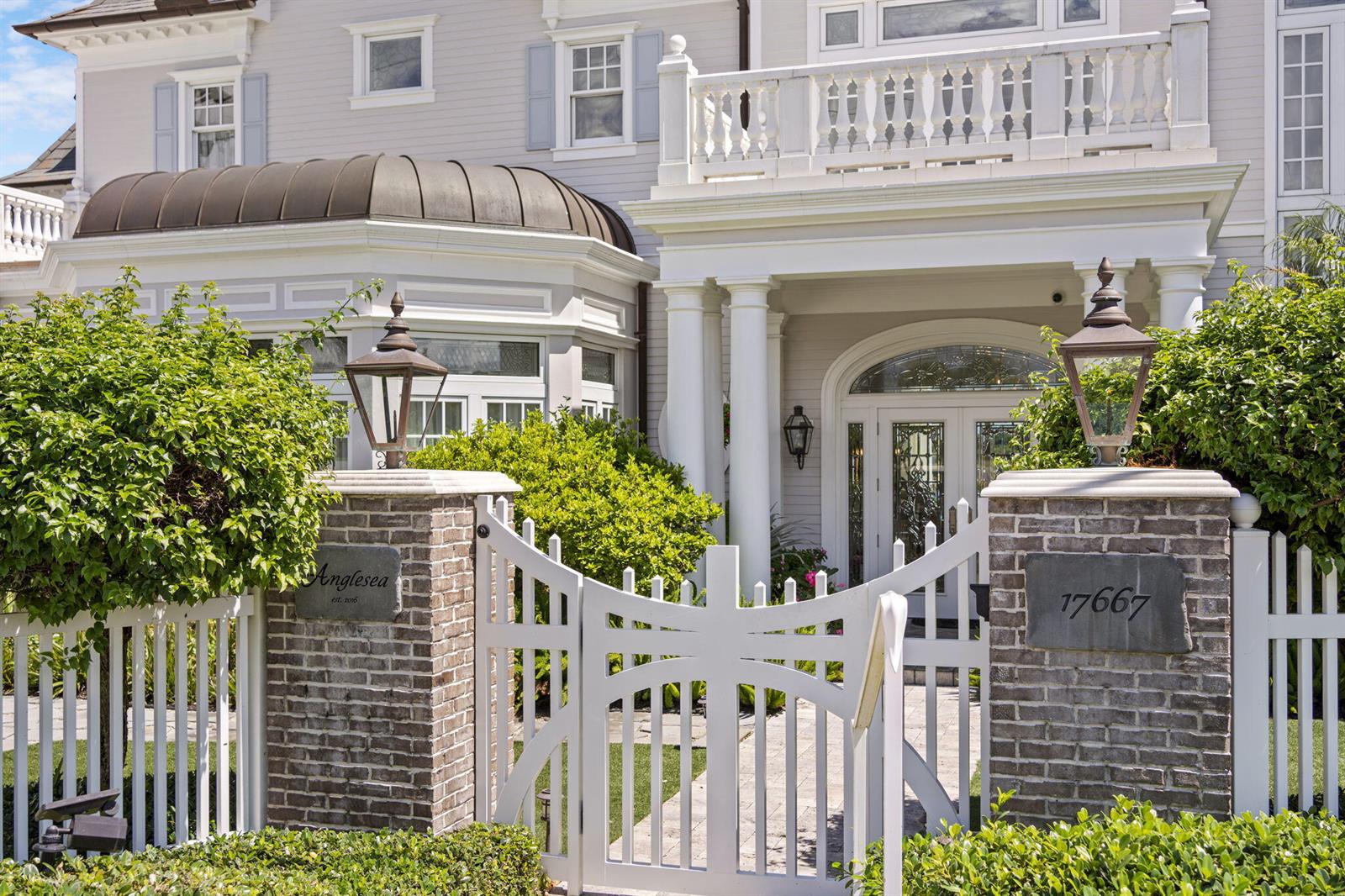 A white picket gate opens to a brick-pillared entrance of a light gray house — 17667 SE FEDERAL Highway, Jupiter FL 33469, JUPITER, FL