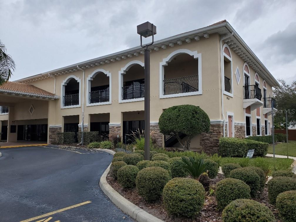 A two-story commercial building with arched balconies, stucco walls, and stone veneer accents — 2984 ALAFAYA TRAIL, OVIEDO, FL