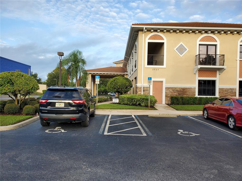 A black SUV and a red sedan are parked in handicap spaces outside a building — 2984 ALAFAYA TRAIL, OVIEDO, FL