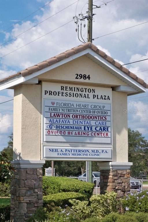 A stone-based monument sign displays the names of various professional businesses at a plaza entrance — 2984 ALAFAYA TRAIL, OVIEDO, FL
