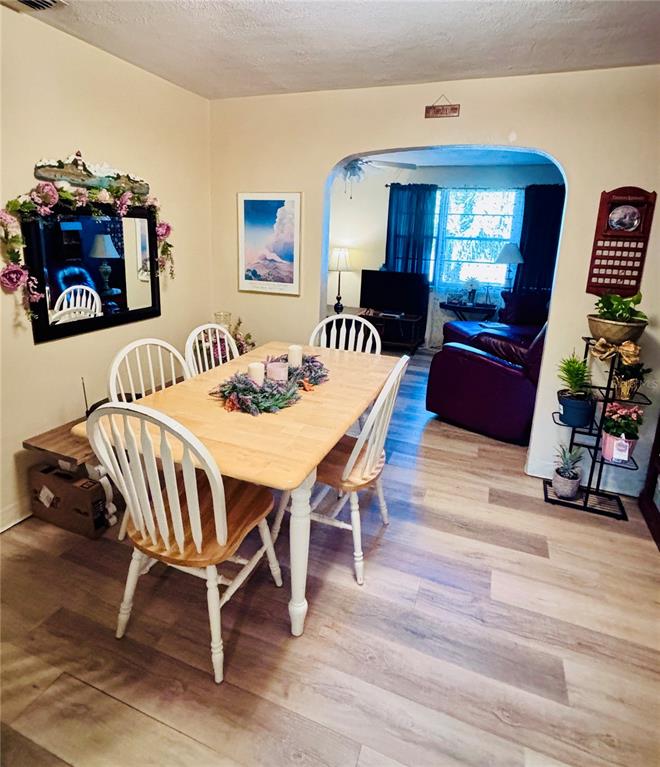 A dining area with a wooden table and chairs opens into a living room — 3137 NW 6TH STREET, GAINESVILLE, FL