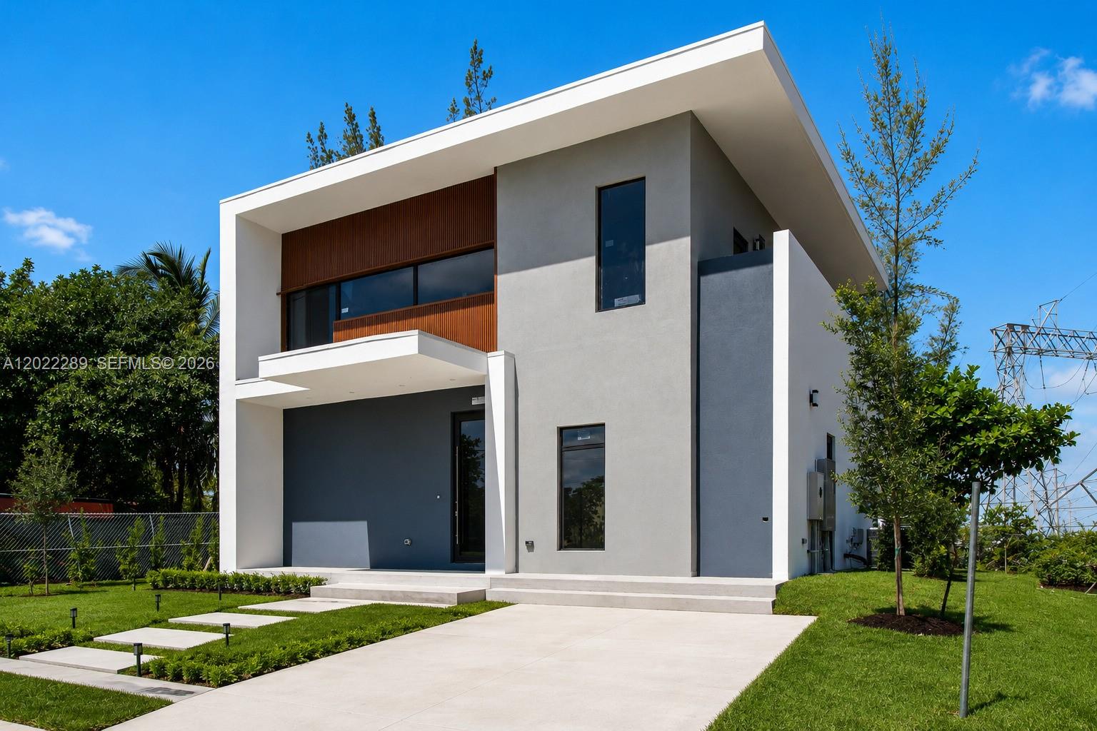 A modern two-story house features a flat roof, gray and white stucco, and wood-slat accents — 201 NW 14 WAY, Dania Beach FL 33004, DANIA BEACH, FL