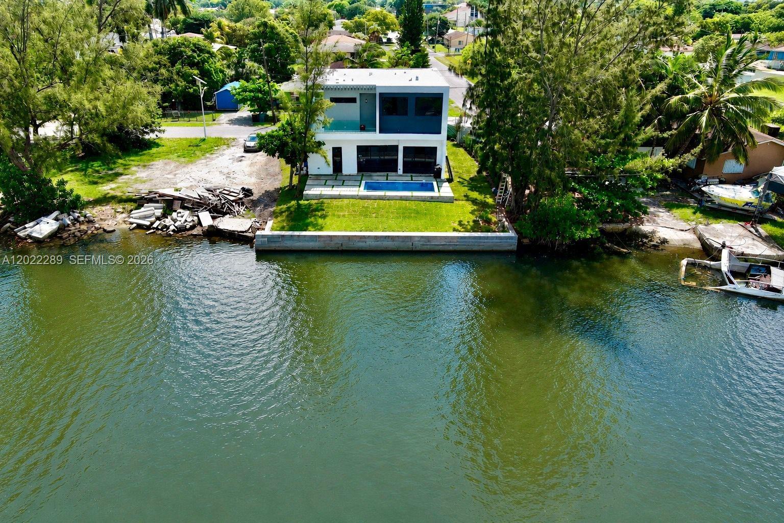 An aerial view of a modern two-story house with a pool overlooking a canal — 201 NW 14 WAY, Dania Beach FL 33004, DANIA BEACH, FL