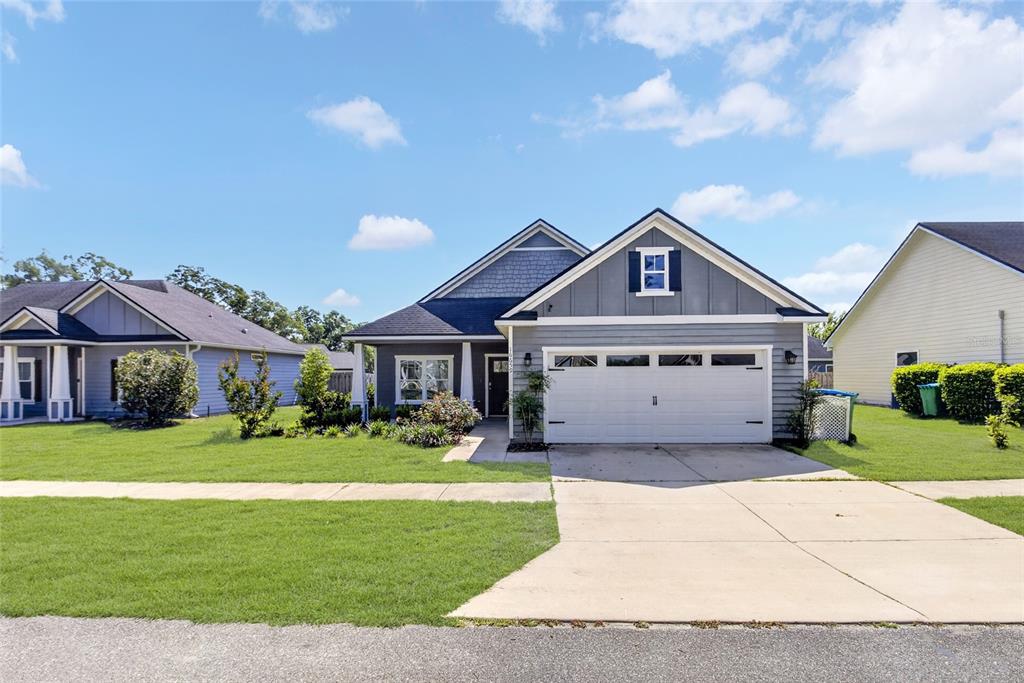 A gray single-story house with a white garage door and a front lawn — 16659 NW 192ND TERRACE, HIGH SPRINGS, FL