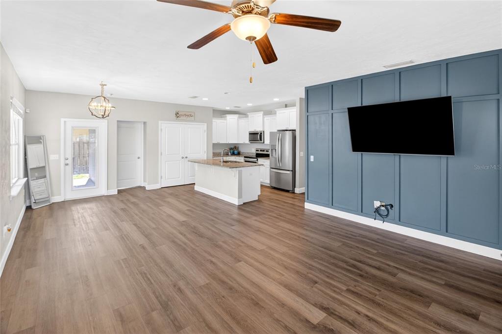 An open-concept living area features wood-look flooring, a blue accent wall, and a kitchen island — 16659 NW 192ND TERRACE, HIGH SPRINGS, FL