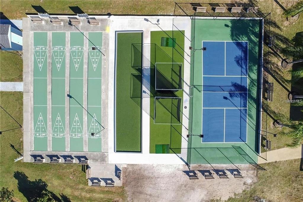 An aerial view shows a recreational area with shuffleboard courts, batting cages, and a pickleball court — 10029 HAMP DRIVE, DADE CITY, FL
