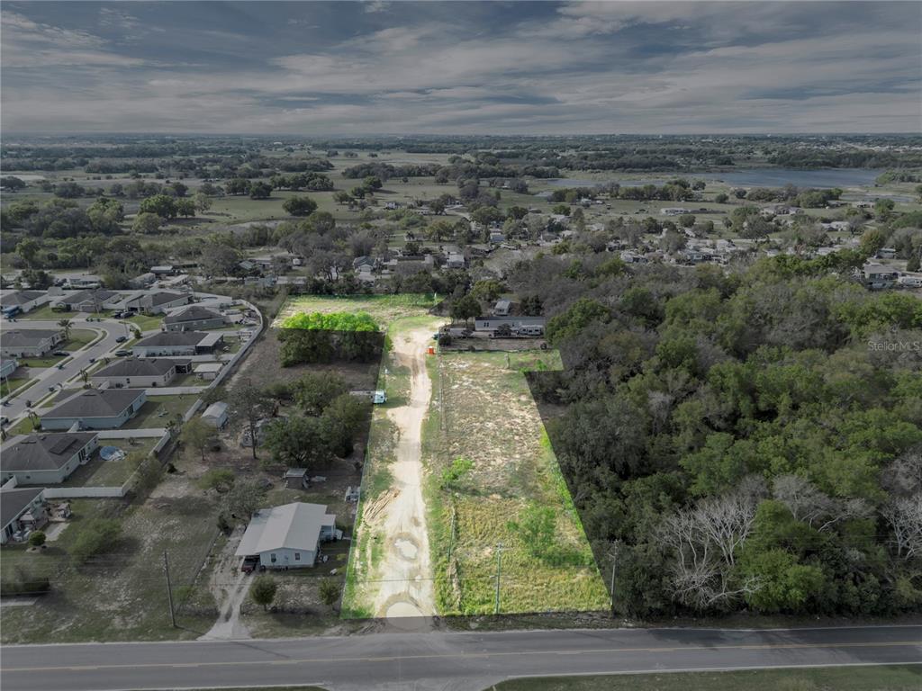 An aerial view shows a long, narrow, partially cleared lot bordered by trees and houses — 701 MYSTERY HOUSE ROAD, DAVENPORT, FL
