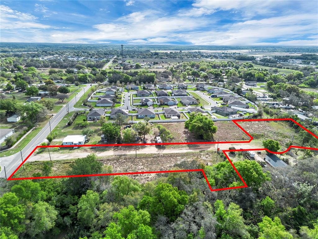 An aerial view shows a large, irregularly shaped vacant lot outlined in red — 701 MYSTERY HOUSE ROAD, DAVENPORT, FL