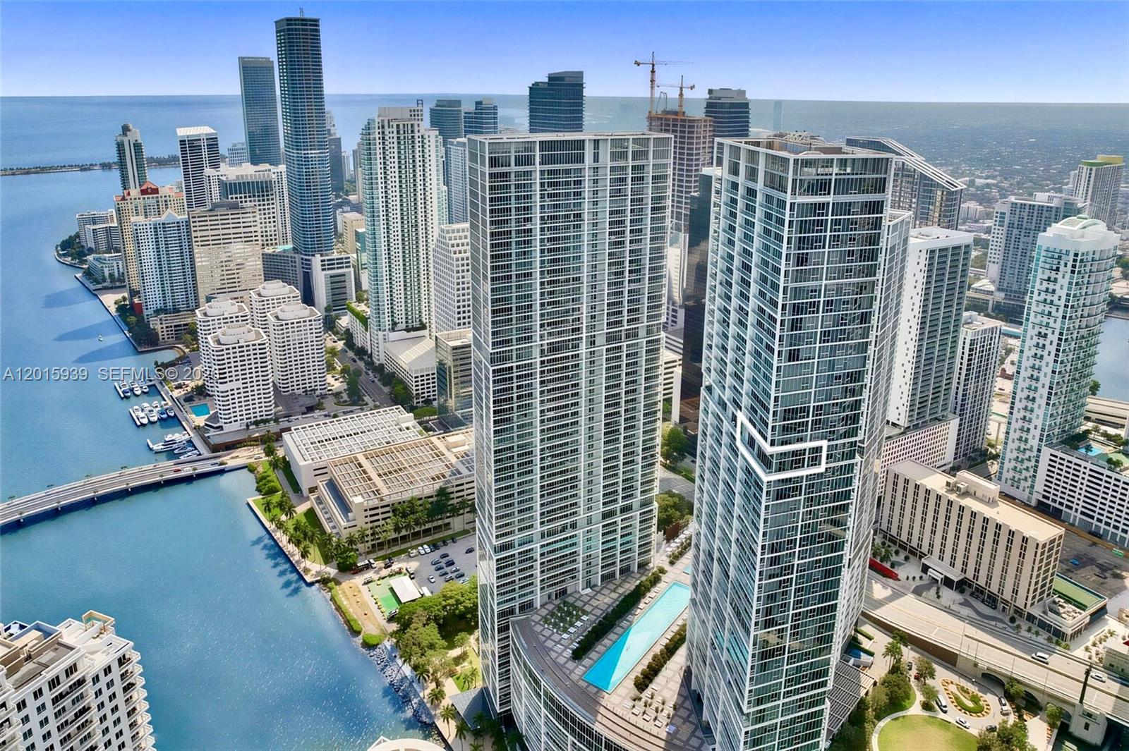 An aerial view shows two prominent modern skyscrapers in a dense urban waterfront city — 465 Brickell Ave # 4101, Miami FL 33131, MIAMI, FL