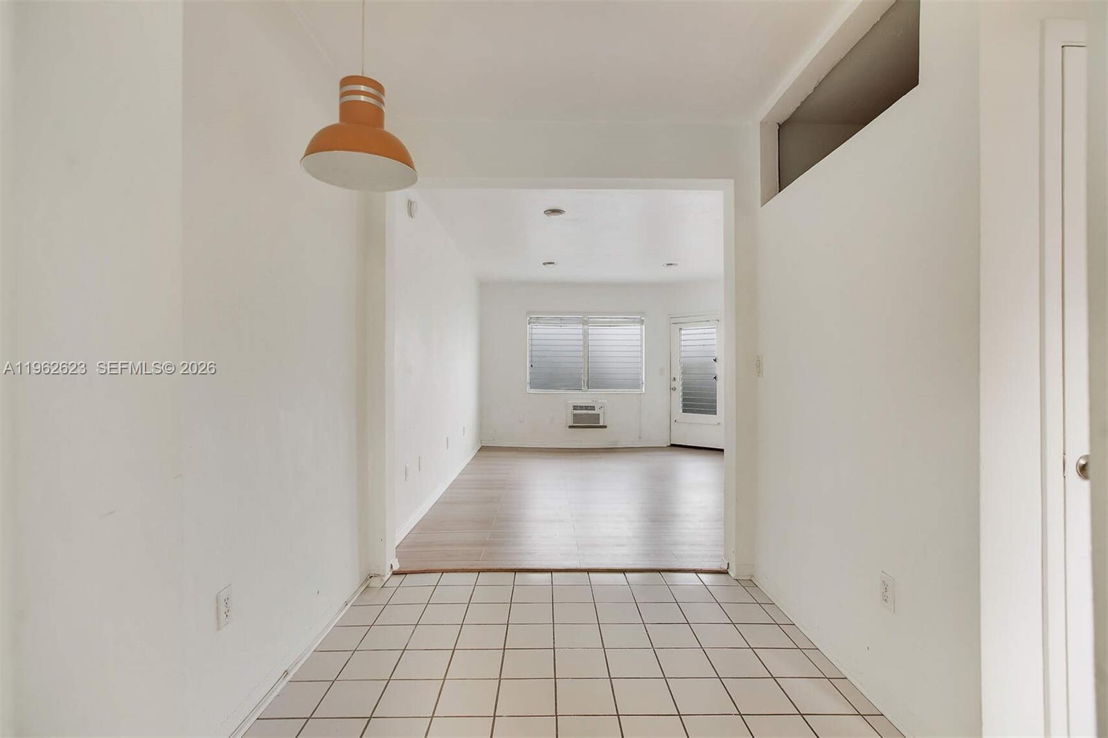 A tiled entryway leads into a living area with wood-look flooring and a window — 835 Meridian Ave # 3, Miami Beach FL 33139, MIAMI BEACH, FL