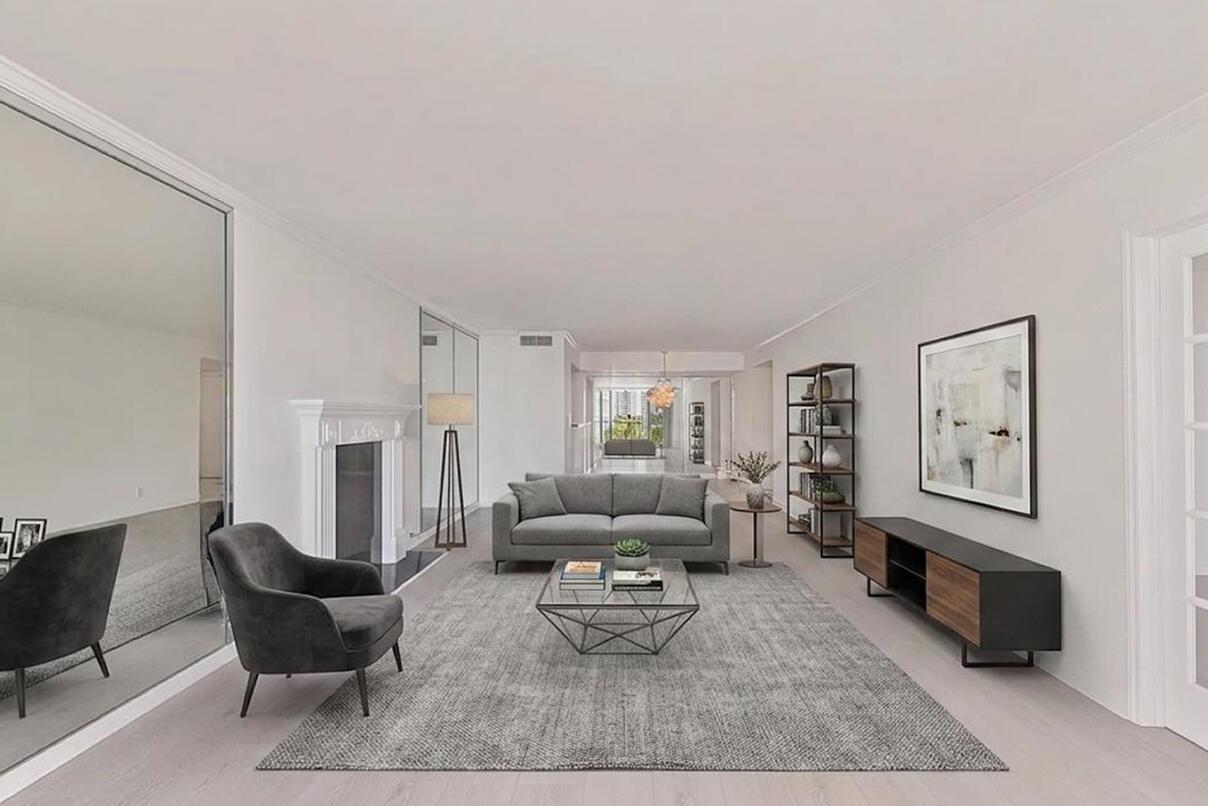 A living room with a fireplace, gray sofa, armchair, area rug, and mirrored walls — 1370 S Ocean Boulevard # 602, Pompano Beach FL 33062, POMPANO BEACH, FL