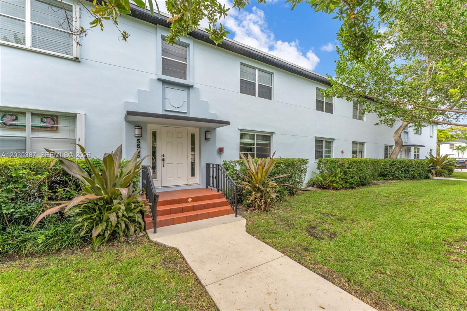 A light blue two-story apartment building features a white front door and concrete walkway — 5685 SW 80th St # 58B, Miami FL 33143, MIAMI, FL