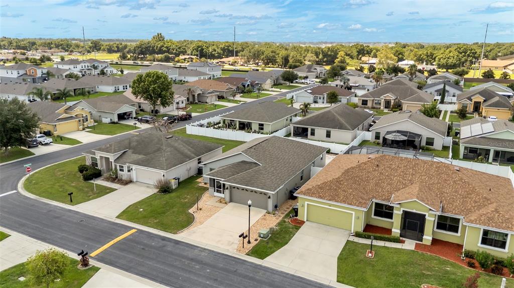 An aerial view shows a suburban neighborhood with single-family homes, paved streets, and green lawns — 1144 HIGH SEAS STREET, WINTER HAVEN, FL