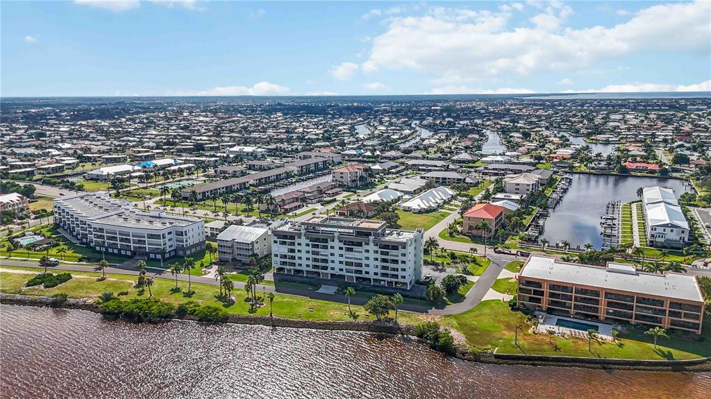 Aerial view of waterfront apartment buildings surrounded by residential neighborhoods and canals — 1500 PARK BEACH CIRCLE UNIT 6C, PUNTA GORDA, FL
