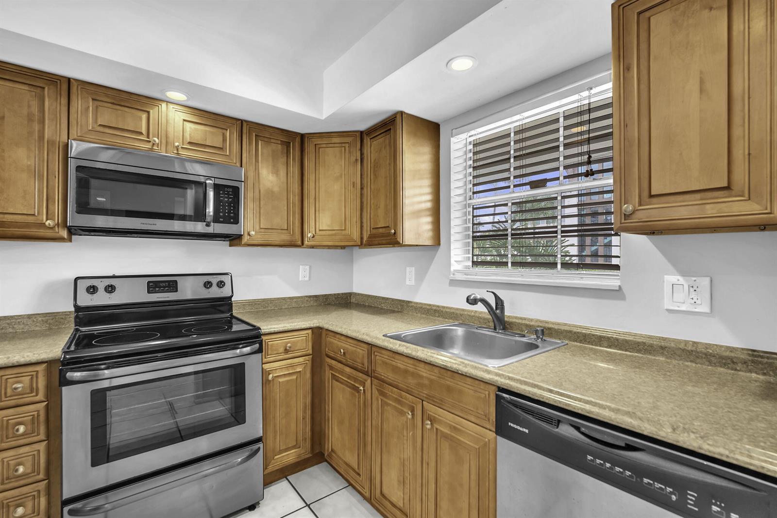 A kitchen features wood cabinets, stainless steel appliances, and tan countertops — 2130 NE 36th Street # 63, Lighthouse Point FL 33064, LIGHTHOUSE POINT, FL