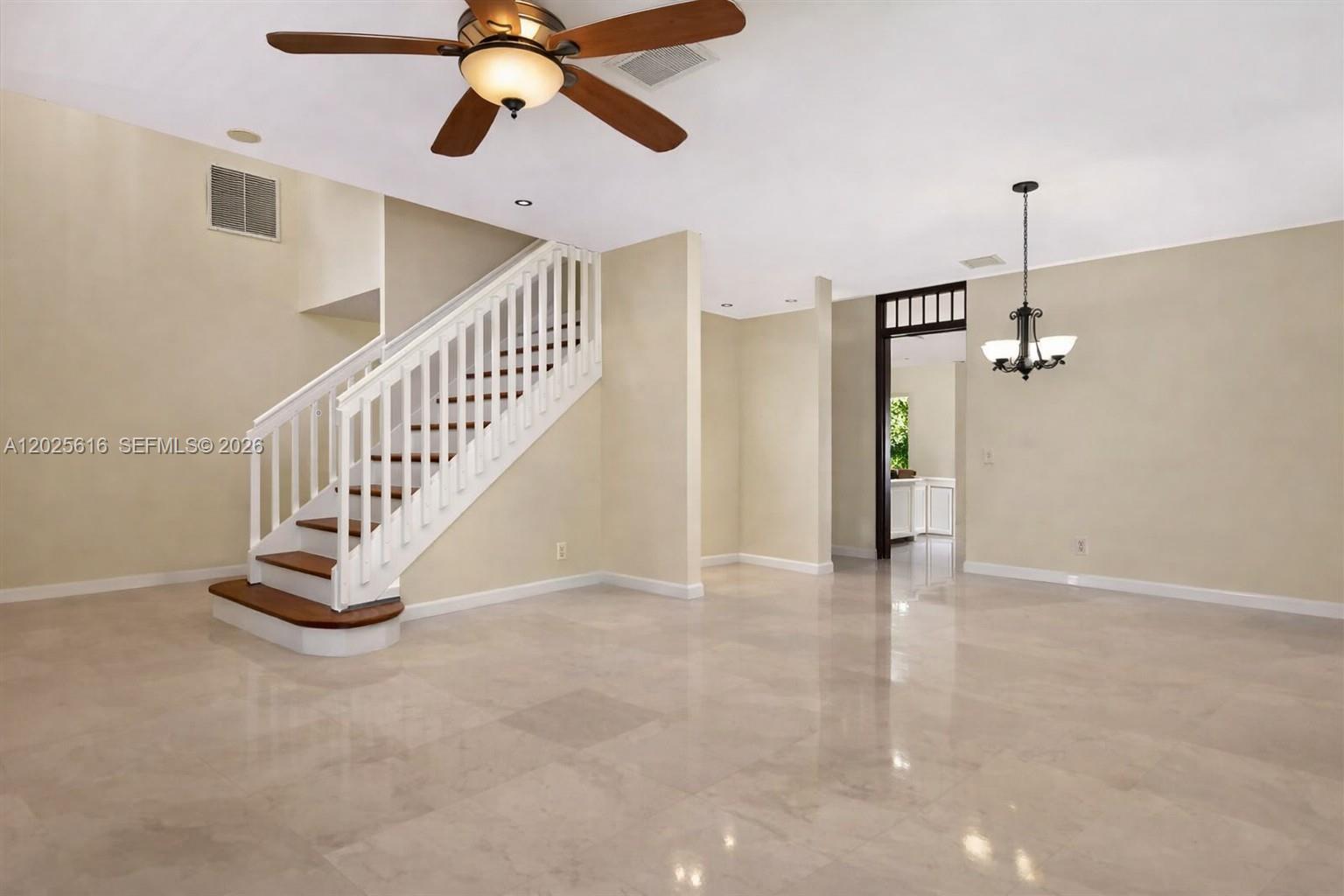A living room features a staircase with white railings, tile flooring, and a ceiling fan — 1319 Croton Ct, Weston FL 33327, WESTON, FL