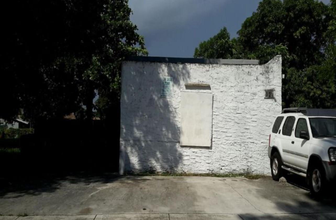 A white, textured exterior wall of a building stands next to a parked white SUV — 237 NW 11th St, Pompano Beach FL 33060, POMPANO BEACH, FL