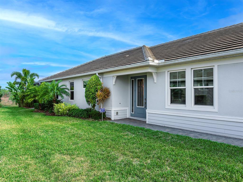 A single-story house with a gray exterior, a tiled roof, and a front entryway — 1010 CROSSWIND AVENUE, SARASOTA, FL
