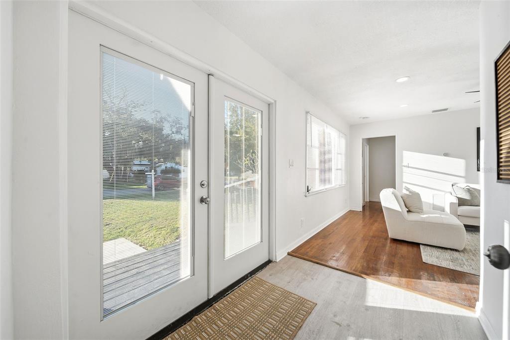 A bright sunroom features white walls, light flooring, and glass doors opening to a yard — 3007 KNOLLWOOD CIRCLE, ORLANDO, FL