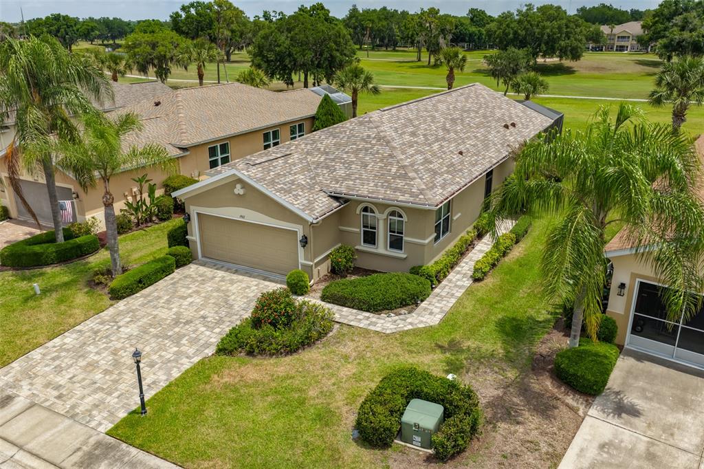 An aerial view shows a single-story house with a paved driveway and a shingled roof — 1907 STERLING GLEN COURT, SUN CITY CENTER, FL