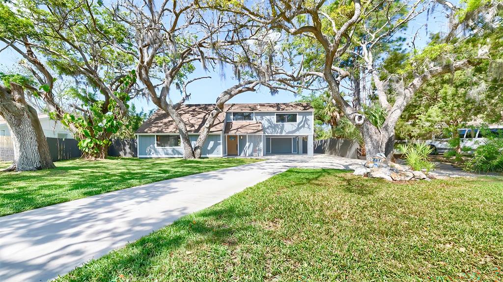 A two-story house with a concrete driveway and large oak trees in the front yard — 7331 DIANNE DRIVE, NEW PORT RICHEY, FL