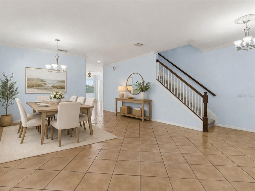 A dining area with a wooden table and chairs sits beside a staircase with railings — 8840 CAMERON CREST DRIVE, TAMPA, FL