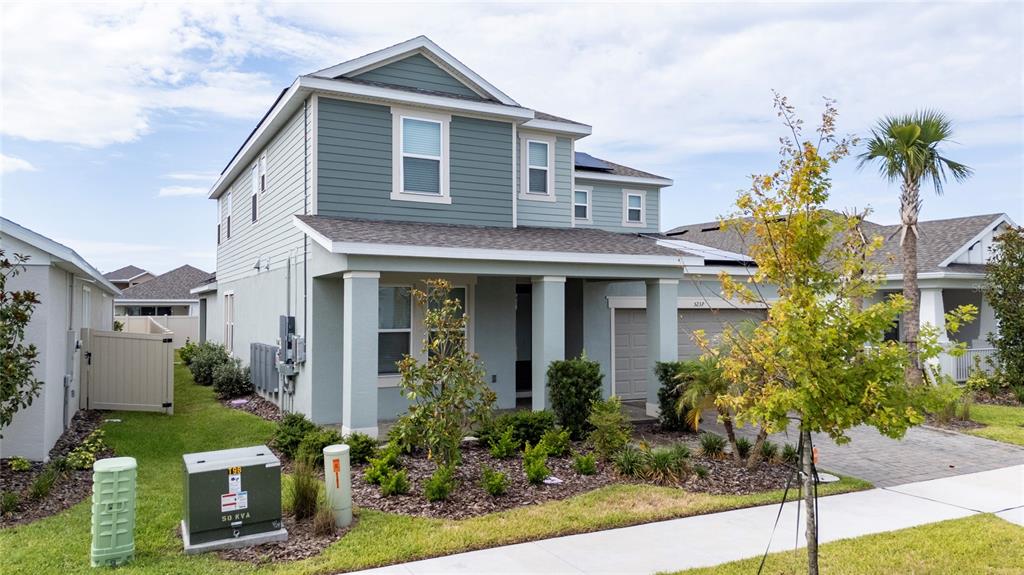 A two-story house with light blue siding, a covered front porch, and a paved driveway — 5237 STONE RIDGE PLACE, ST CLOUD, FL