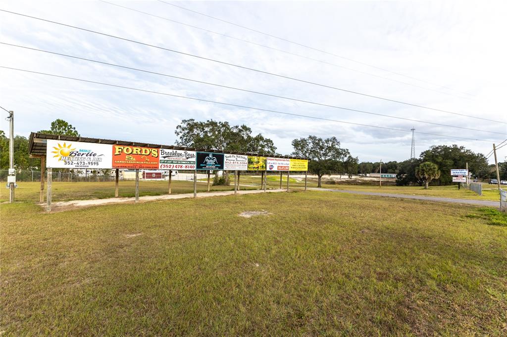 A row of advertising billboards stands on a grassy lot under a cloudy sky — 1177 SE KEYSTONE AVENUE, KEYSTONE HEIGHTS, FL