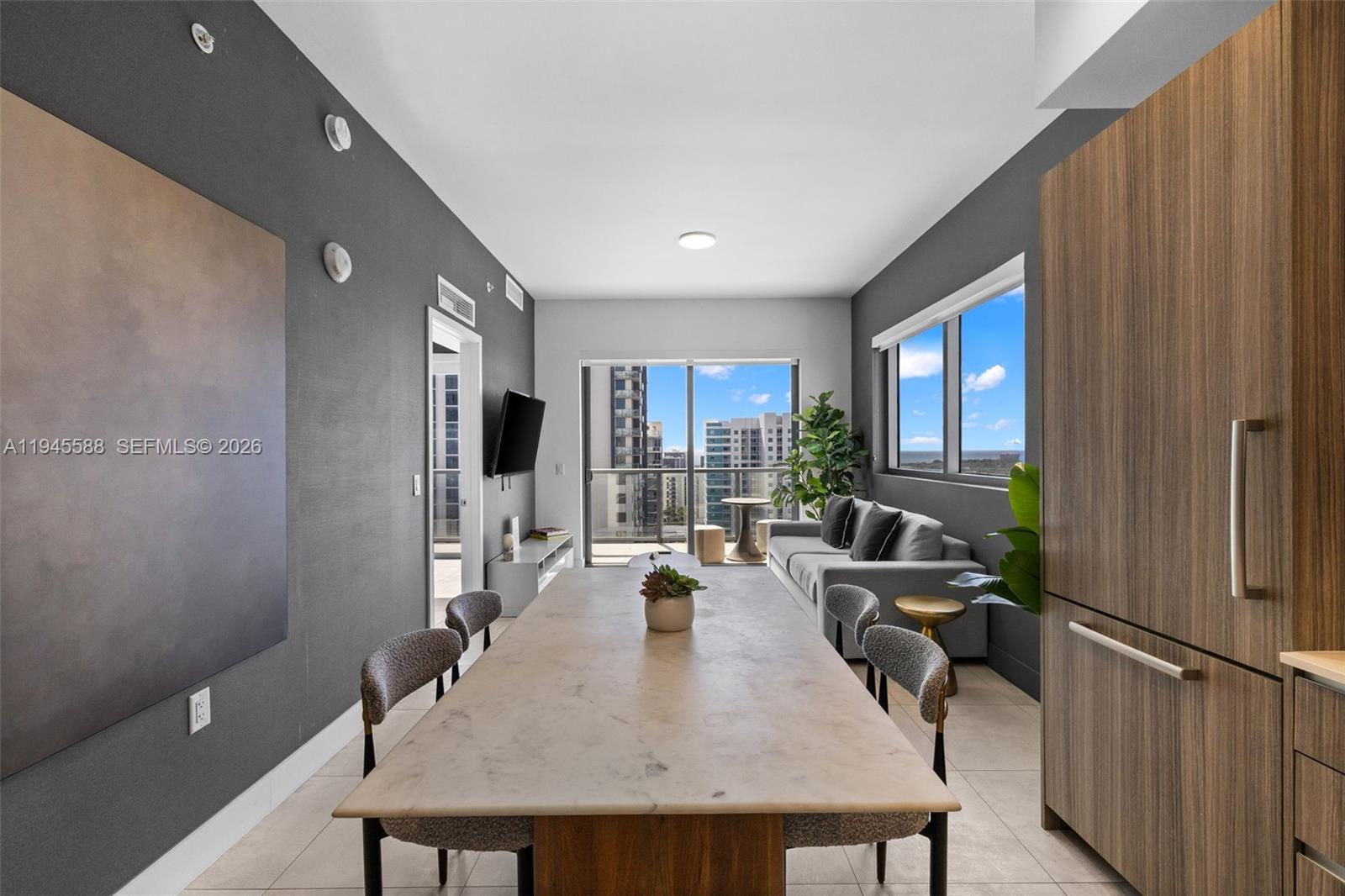 A modern dining and living area features a marble table, gray sofa, and balcony views — 239 SW 9th St # 2102, Miami FL 33130, MIAMI, FL