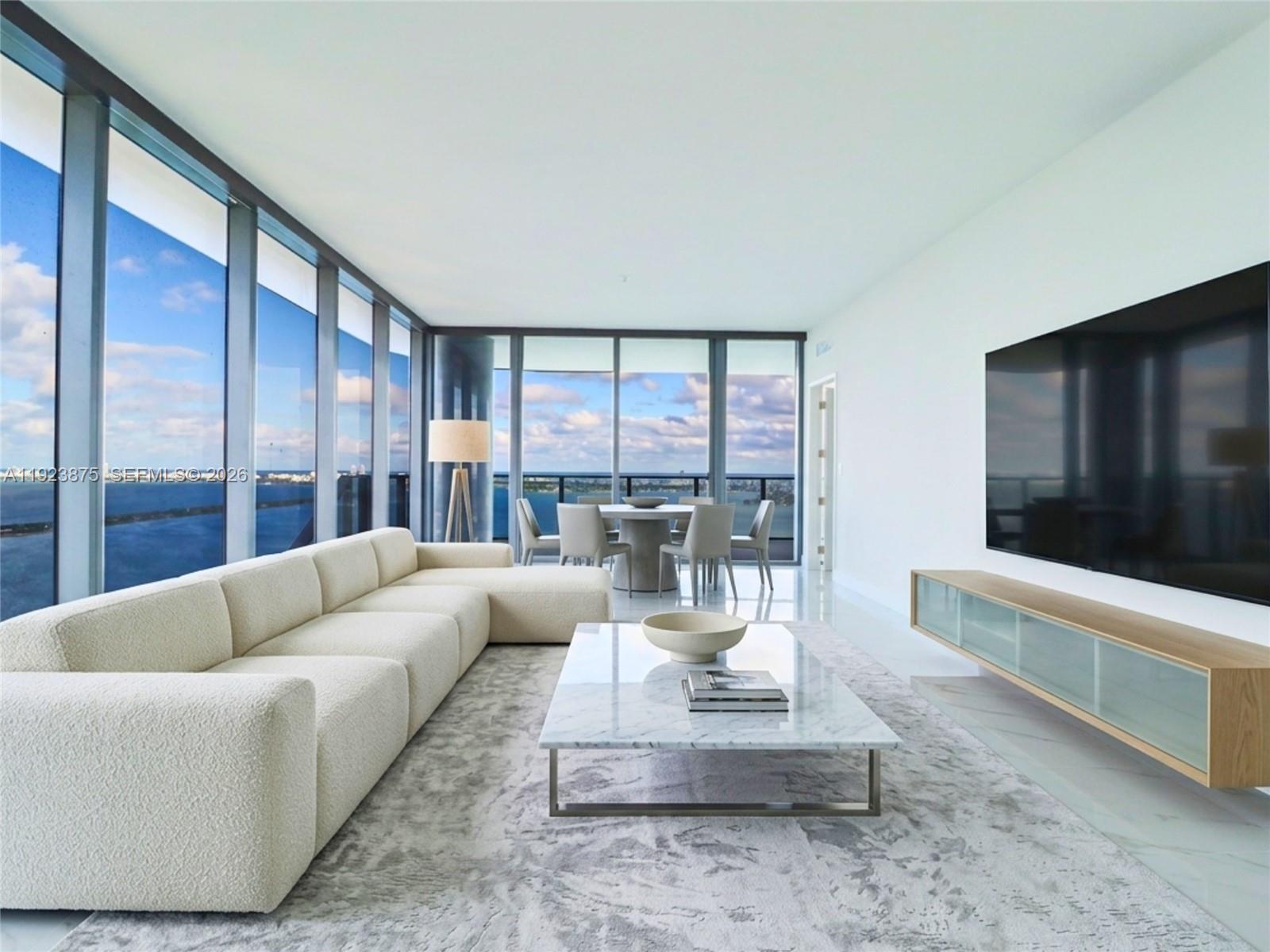 A modern living room features a white sectional sofa, marble coffee table, and floor-to-ceiling windows — 700 NE 24 st # 4201, Miami FL 33137, MIAMI, FL